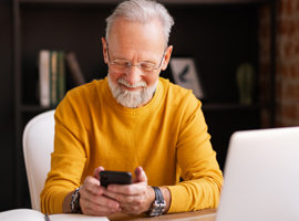 Pensioner looking at phone and smiling